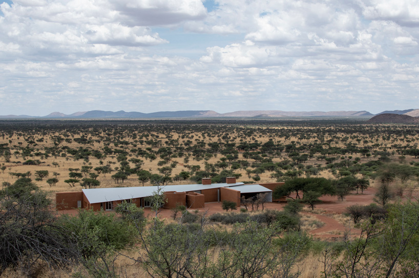 slee & co. architects' red earth game lodge emerges from the namibian landscape