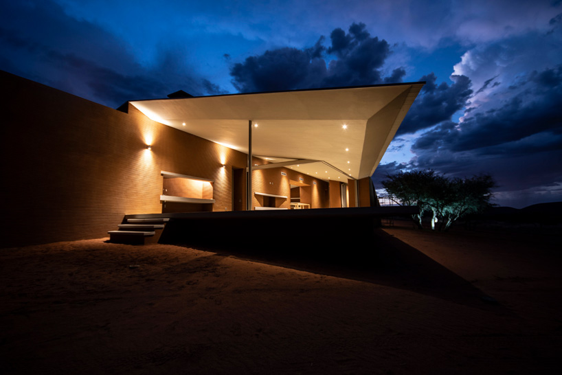 slee & co. architects' red earth game lodge emerges from the namibian landscape