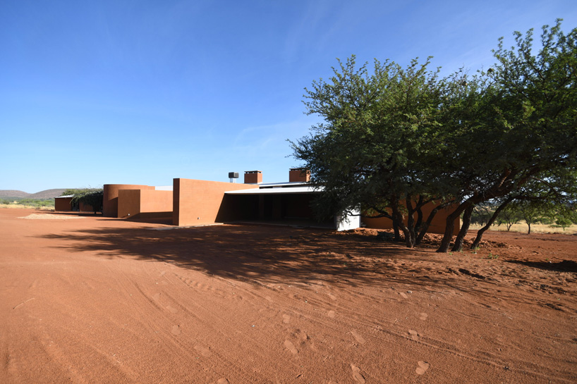 slee & co. architects' red earth game lodge emerges from the namibian landscape
