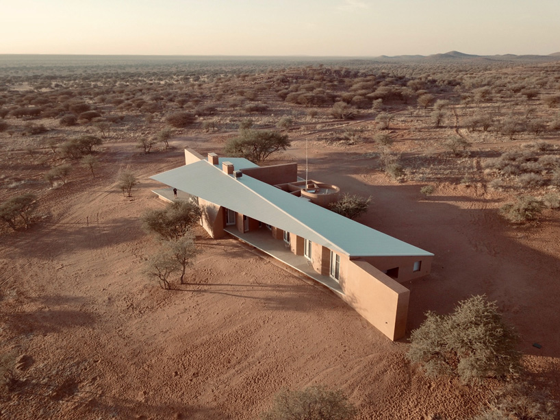 slee & co. architects' red earth hunting lodge emerges from the namibian landscape