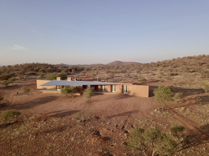 slee & co. architects' red earth game lodge emerges from the namibian landscape