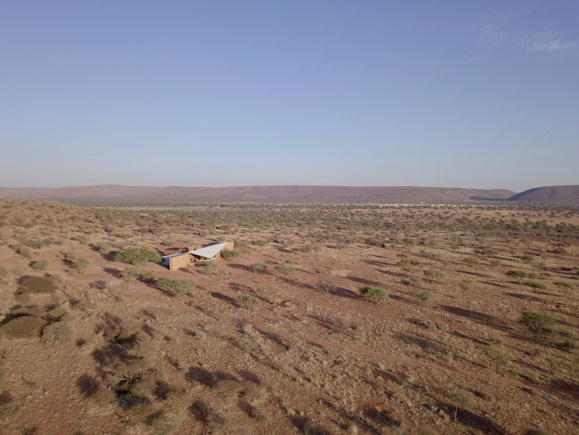 slee & co. architects' red earth hunting lodge emerges from the namibian landscape