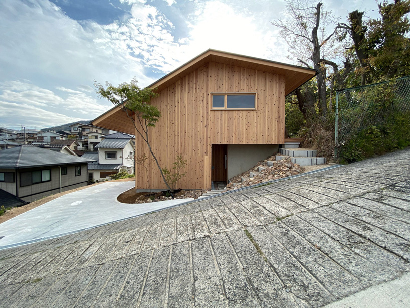 atelier thu splits japanese wooden house between two different terrain levels