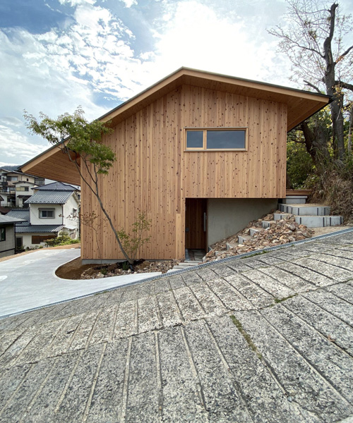 atelier thu splits japanese wooden house between two different terrain levels