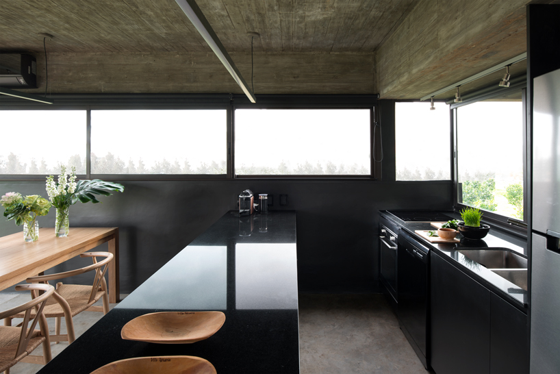 bare concrete volumes + black finishes define castaños house in argentina