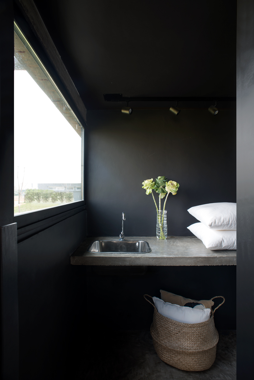 bare concrete volumes + black finishes define castaños house in argentina