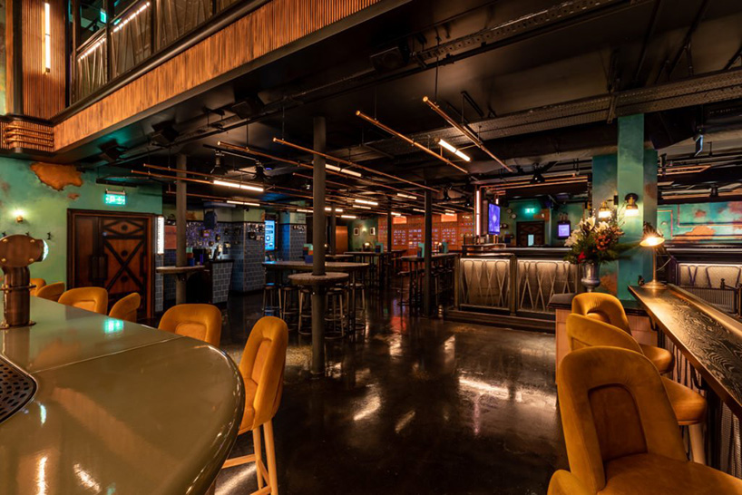 ellis design studio adds art deco elements within industrial, electric bar  interior in london