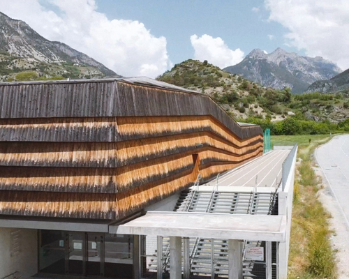 larch cladding folds over a gymnasium in france to echo the mountain topography