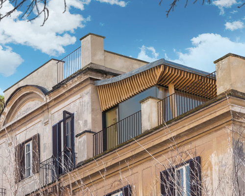 a trestle frame and curved lead roof forms linee minime's penthouse extension in rome