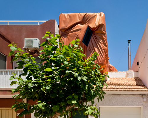 XPIRAL wraps recycled shipping container in orange tarp for 'casa en los urrutias'