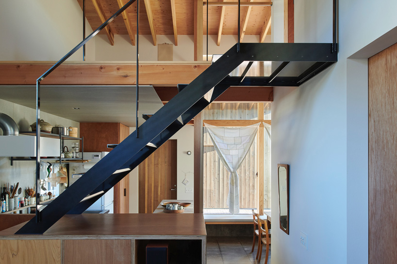 a black steel staircase leads to the house's upper level