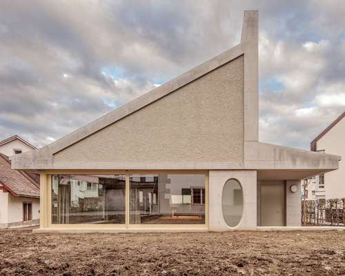 asymmetrical pitched roof tops parish hall by joos & mathys + daniel nyffeler in switzerland