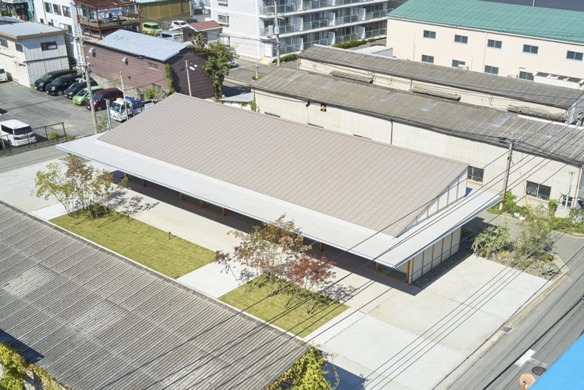 ninkipen! completes gallery for veneer company with deep overhangs in yao, japan