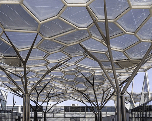 tree-shaped steel columns + organic undulating roof shelter trade show facilities in italy