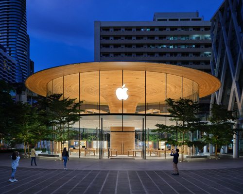 'apple central world' in bangkok is housed beneath a cantilevered tree canopy
