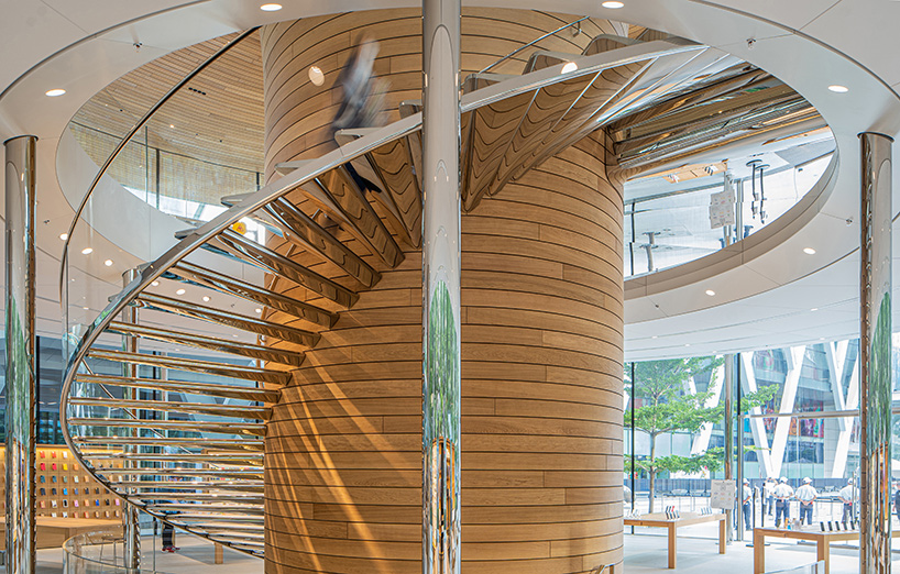 'apple central world' in bangkok is housed beneath a cantilevered tree canopy