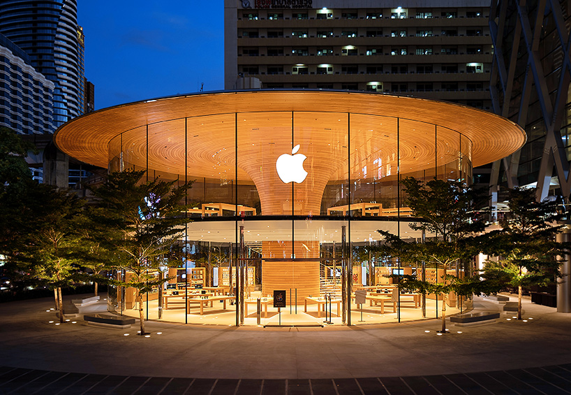 'apple central world' in bangkok is housed beneath a cantilevered tree canopy