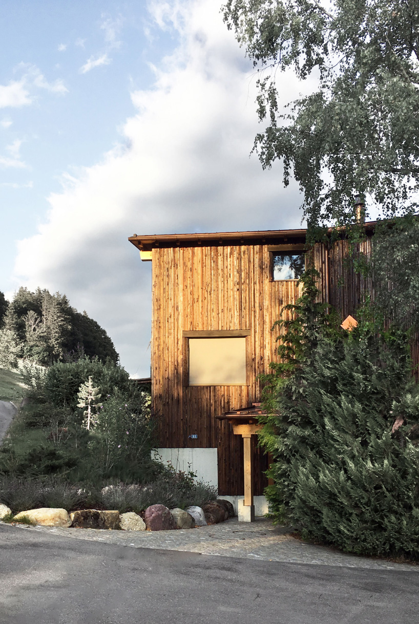 atelier risi combines tree bark + concrete for the exterior of this house in böschi, switzerland