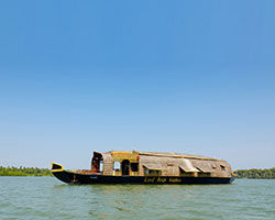 bamboo, wood + colorful fabrics adorn interior of boat house floating οn chapora river, india