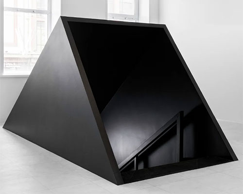 bold sloping cube welcomes visitors to second-hand clothing store in st. petersburg, russia