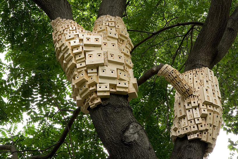 london fieldworks' dense metropolises of wooden birdhouses sprout from tree trunks
