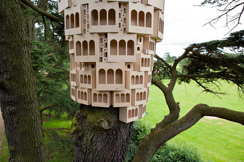 london fieldworks' dense metropolises of wooden birdhouses sprout from tree trunks