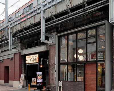 steel H-beams build coffee shop situated under railway elevated bridge in tokyo