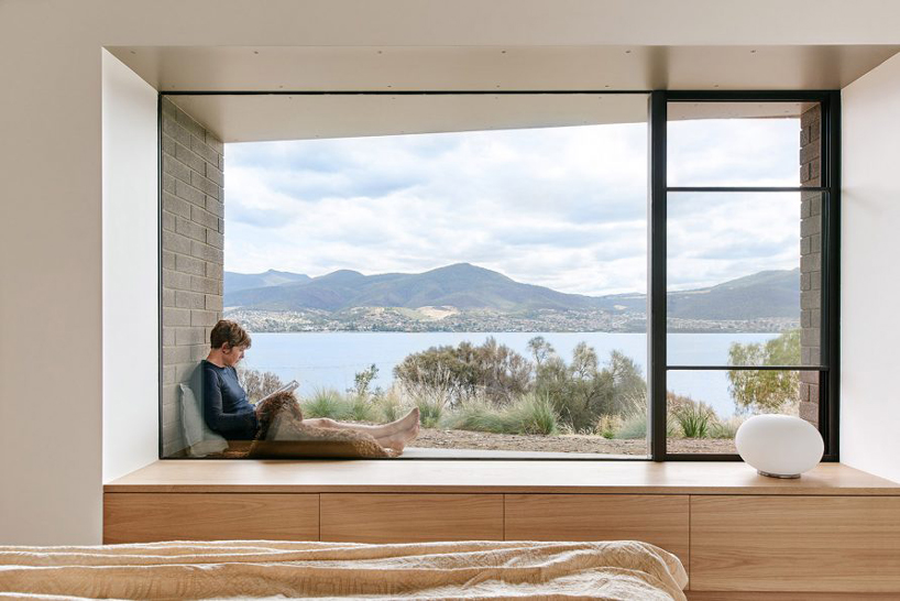this coastal house by topology studio nestles into the landscape of otago bay in tasmania