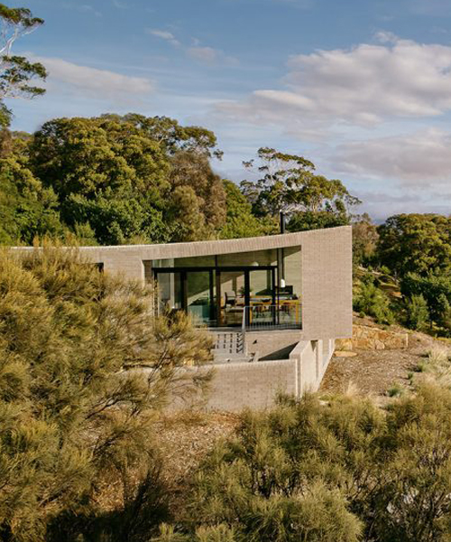 this coastal house by topology studio nestles into the landscape of otago bay in tasmania