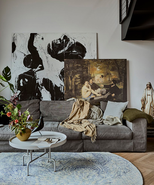 a steel staircase doubles as storage in this poznan apartment designed by UGO