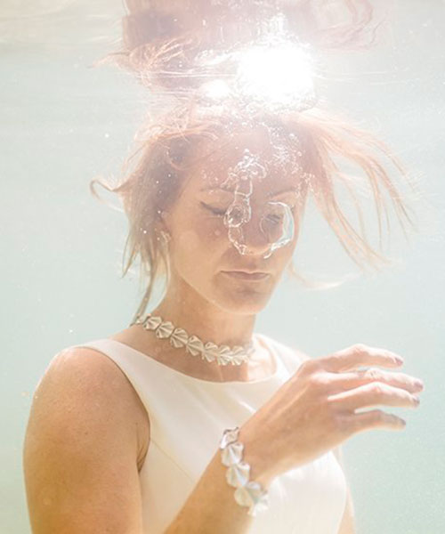 dreamy underwater photography highlights jewelry submerged in clear blue finnish waters