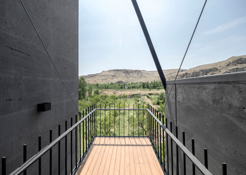 'gray villa' by white cube atelier draws from iran's irregular rocks + mountains