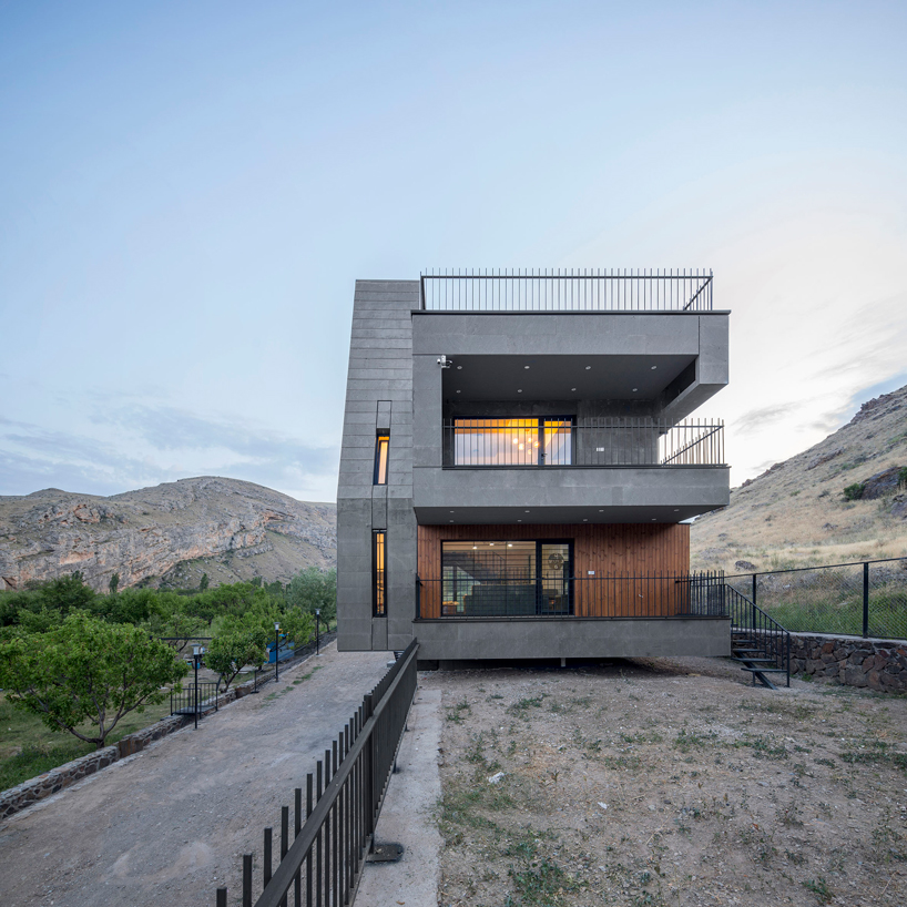 'gray villa' by white cube atelier draws from iran's irregular rocks + mountains