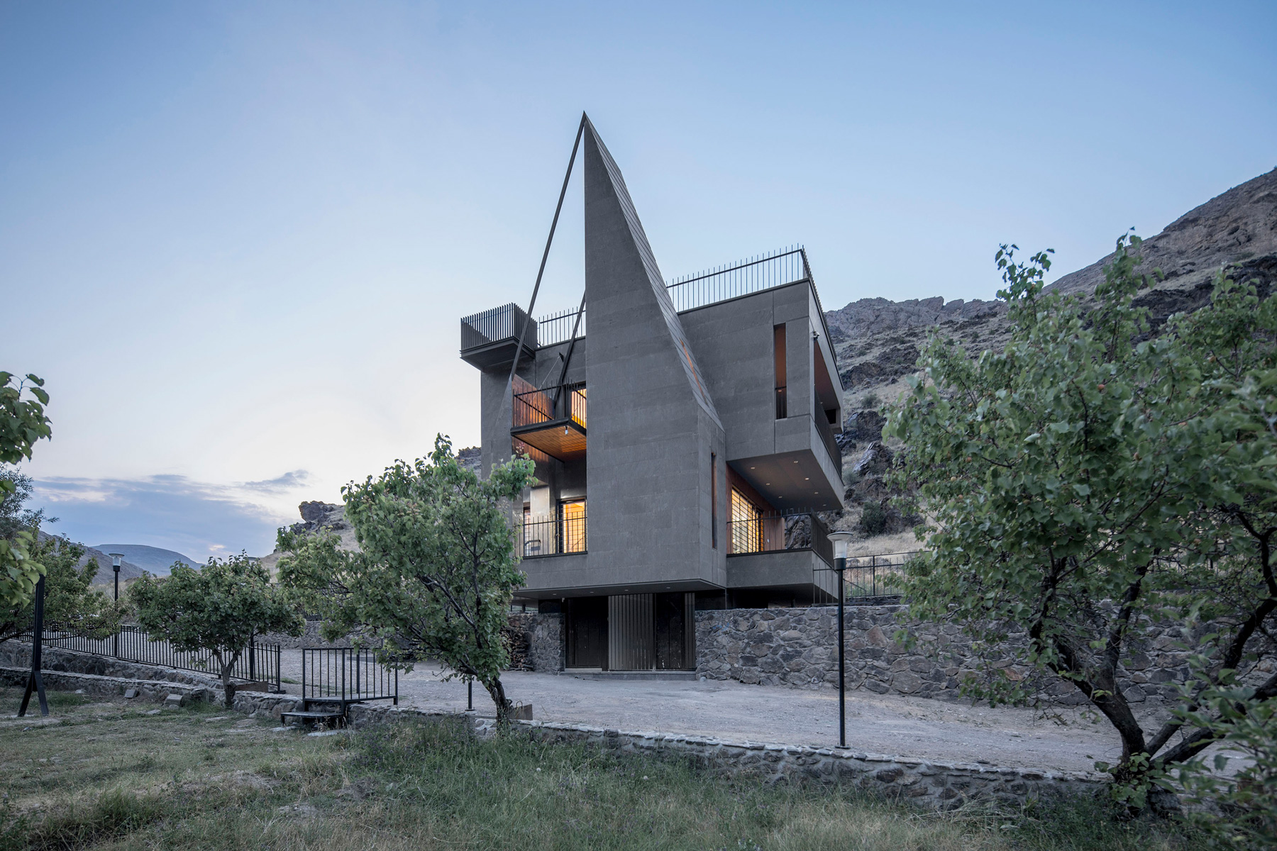 'gray villa' by white cube atelier draws from iran's irregular rocks + mountains