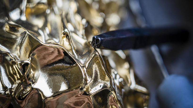 frank gehry designs sculptural gold bottle for hennessy X.O's 150th anniversary