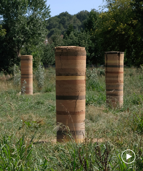 pillars made from the biomass of dead palm trees populate a riverside site in portugal