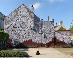 nespoon's giant lace mural in calais, france, pays tribute to the city's unique history