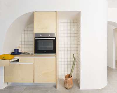 sculptural partition wall with curved openings organizes apartment interior in athens, greece