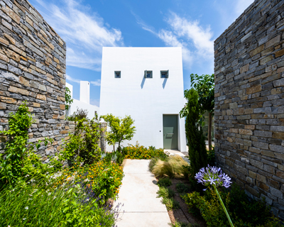 meandering paths wind through two coastal houses by react architects in paros, greece