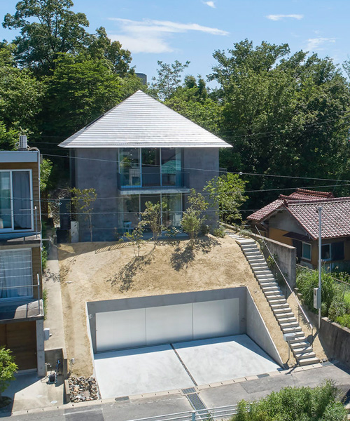 airhouse tops house on a sloping hill in seto, japan, with pyramid hip roof