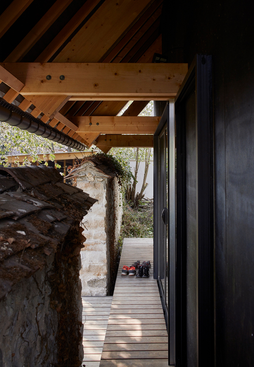 arba is building a wooden house between two old stone walls in rural france