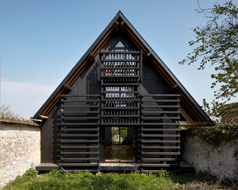 arba is building a wooden house between two old stone walls in rural france