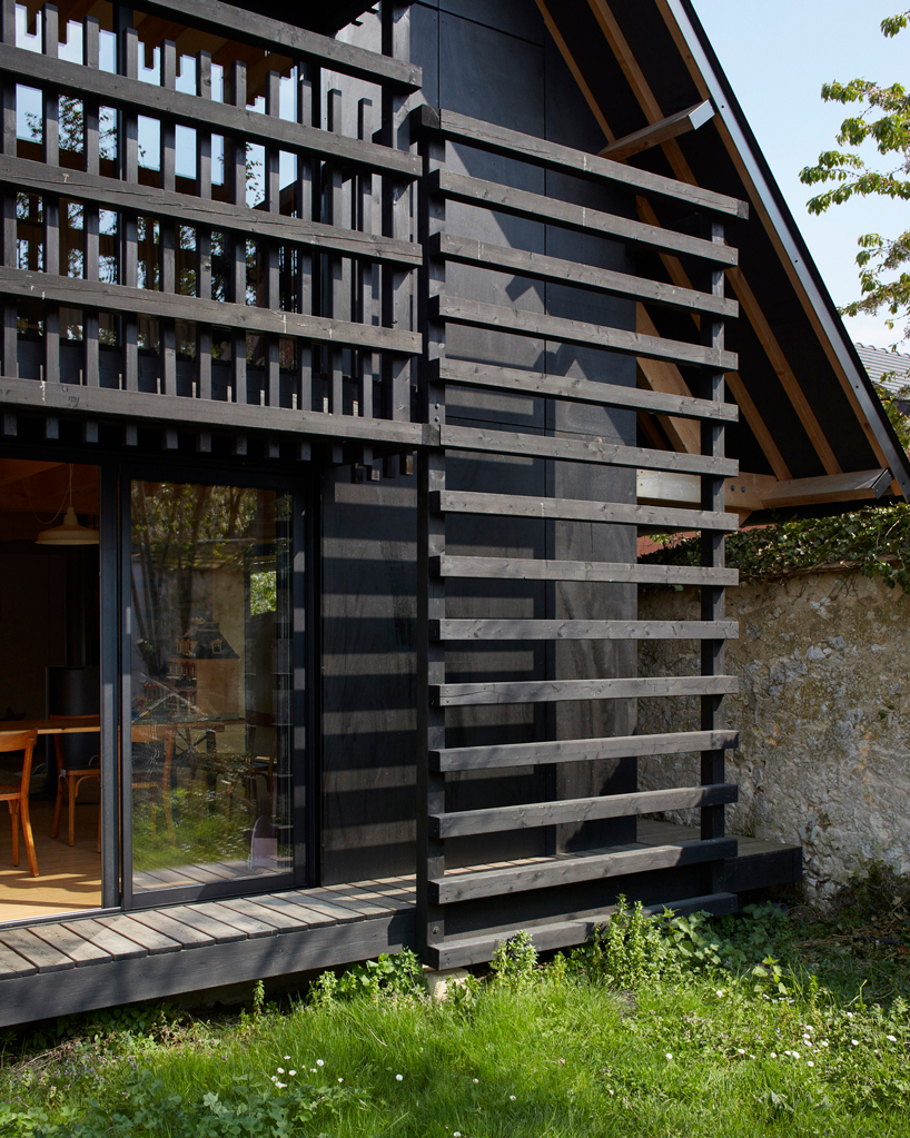 arba is building a wooden house between two old stone walls in rural france