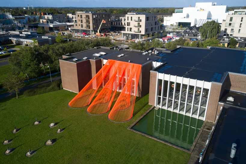two bright orange, mesh fabric installations by behin ha pop up in denmark