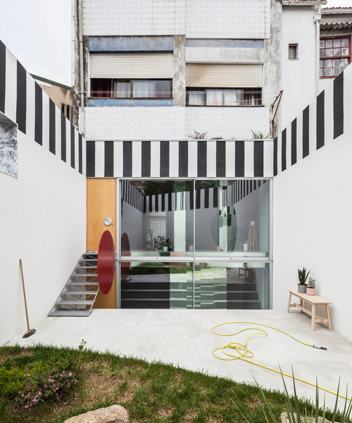 fala atelier uses black + white stripes to frame 'uneven house' in porto