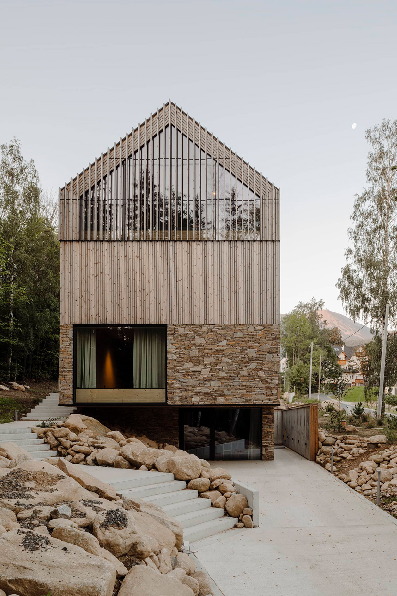 studio de.materia clads twin apartment buildings in stone + wood in poland