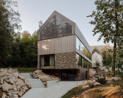 studio de.materia clads twin apartment buildings in stone + wood in poland