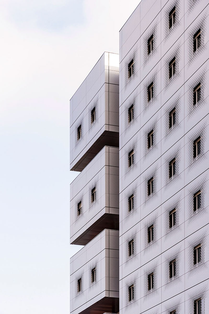 white & bright red perforated metal facade clads student housing by BFV in france