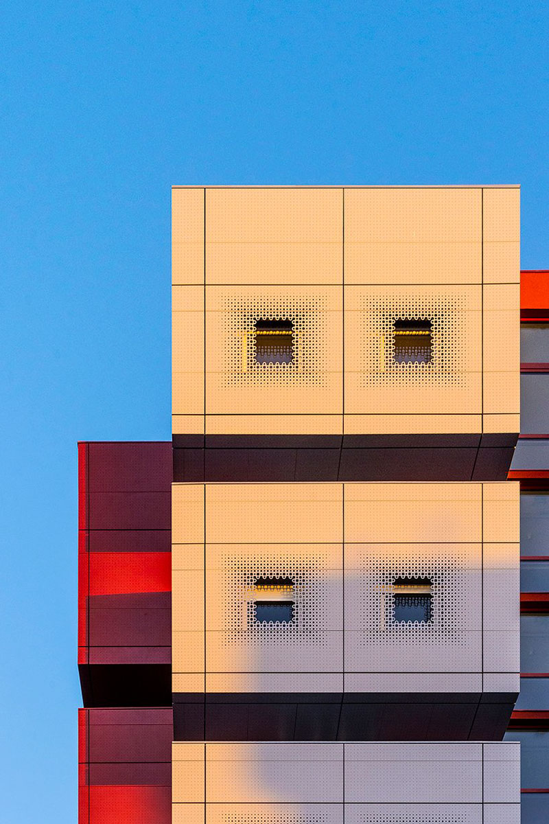 white & bright red perforated metal facade clads student housing by BFV in france