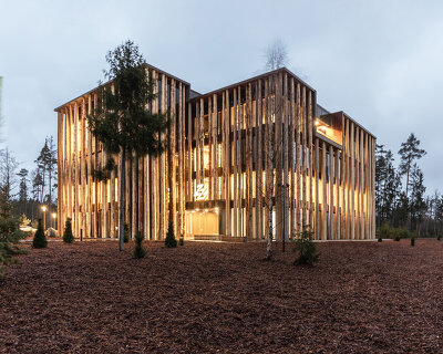 brückner & brückner architekten wraps 'hohes holz' office in a façade of spruce trunks